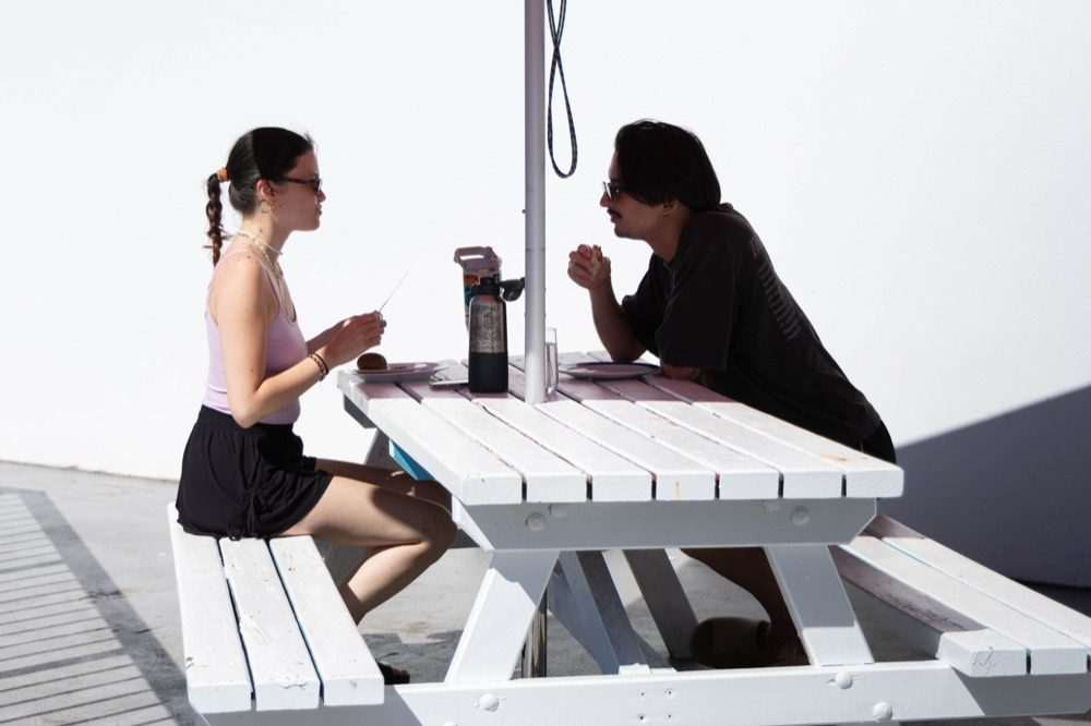 Guests sharing breakfast on the deck at CALI Backpackers