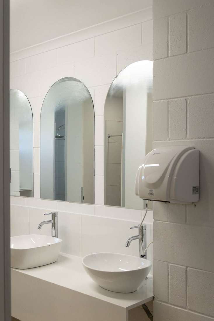 Shared bathrooms with arched mirrors at CALI Backpackers